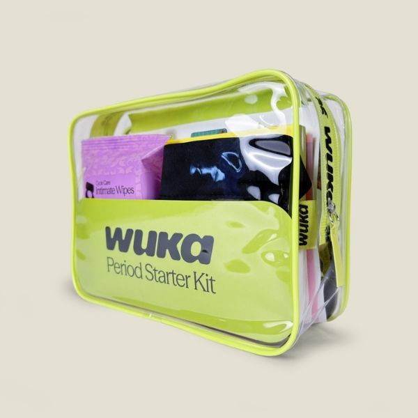 Close-up of the WUKA Period Starter Kit — a clear zip pouch filled with period products, including intimate wipes and period pants.