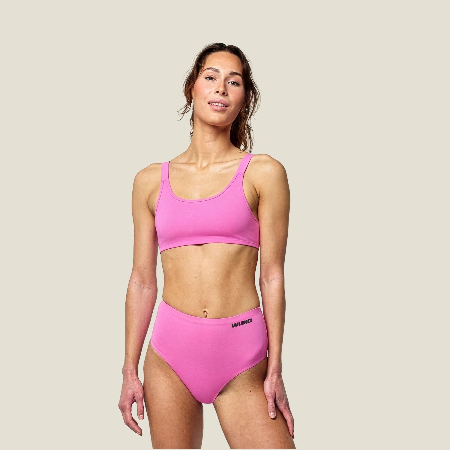 WUKA Stretch™ Midi Brief in pink for heavy flow, shown on model with matching pink bralette – reusable leak-proof period underwear for all-day comfort and flexibility