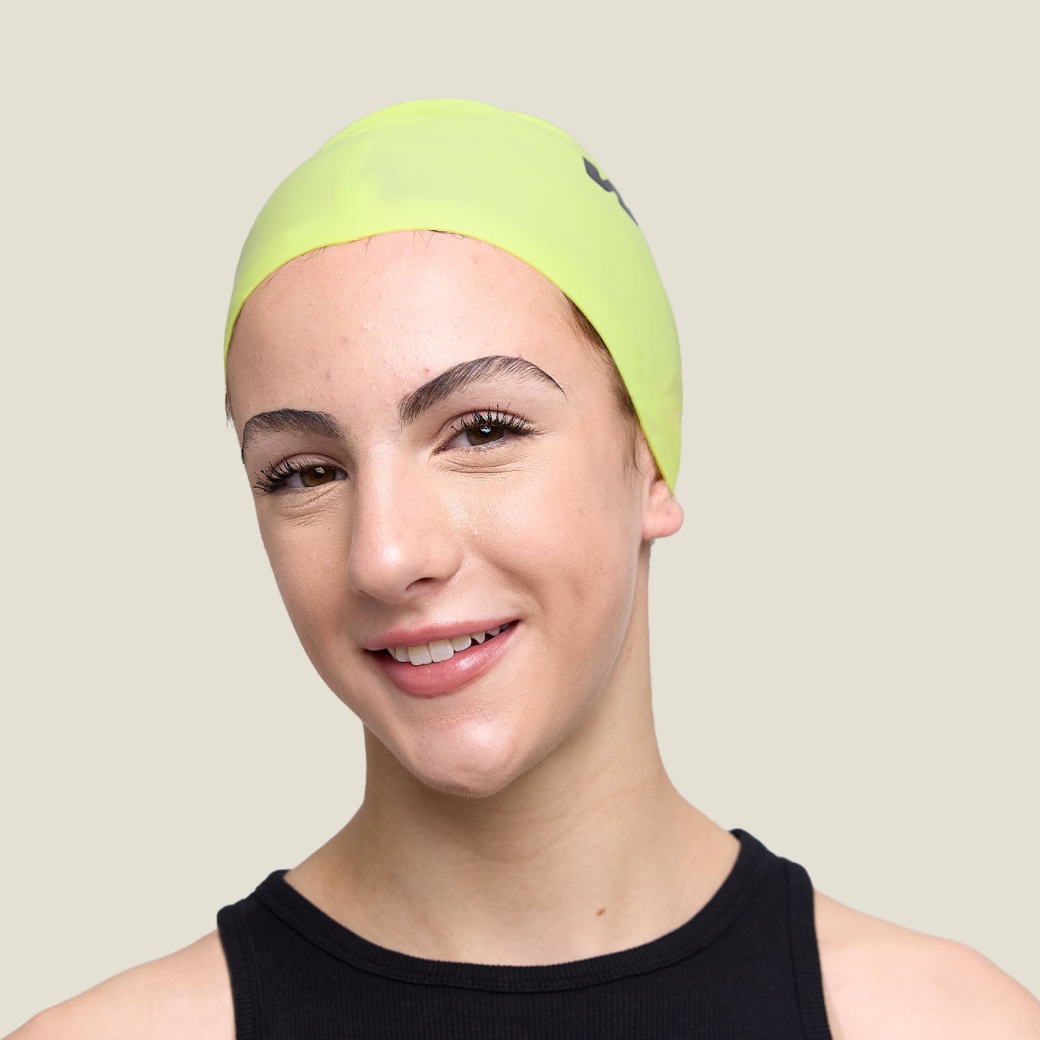 Close-up front view of the WUKA lime punch swim cap — smooth silicone, secure fit.